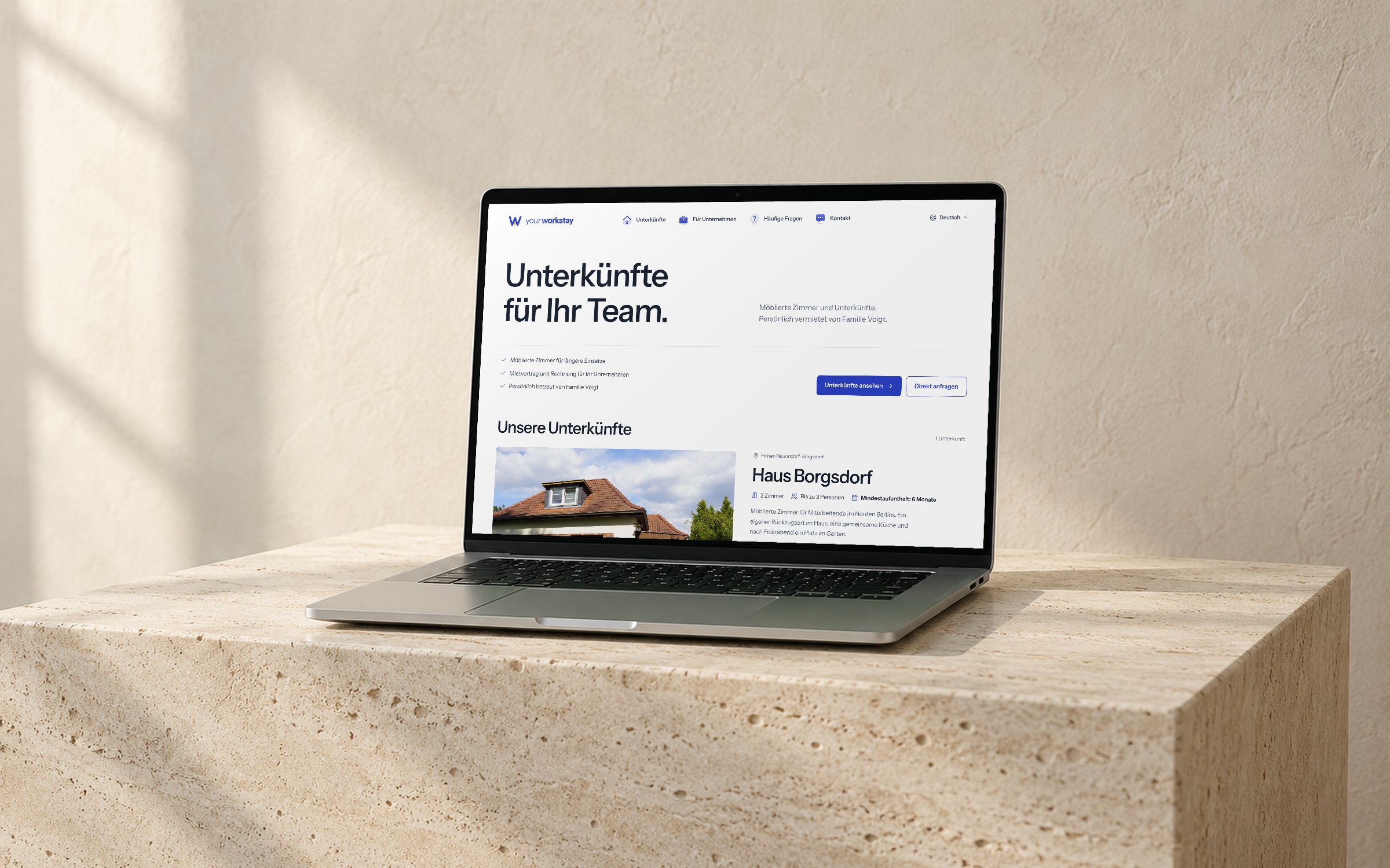 Laptop auf einem hellen Travertinsockel zeigt die Startseite von your workstay